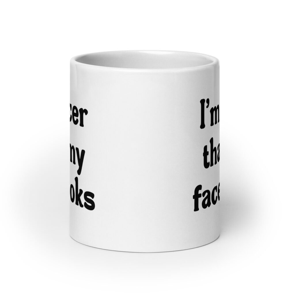 White ceramic coffee mug with the text 'I'm nicer than my face looks' printed on both sides.