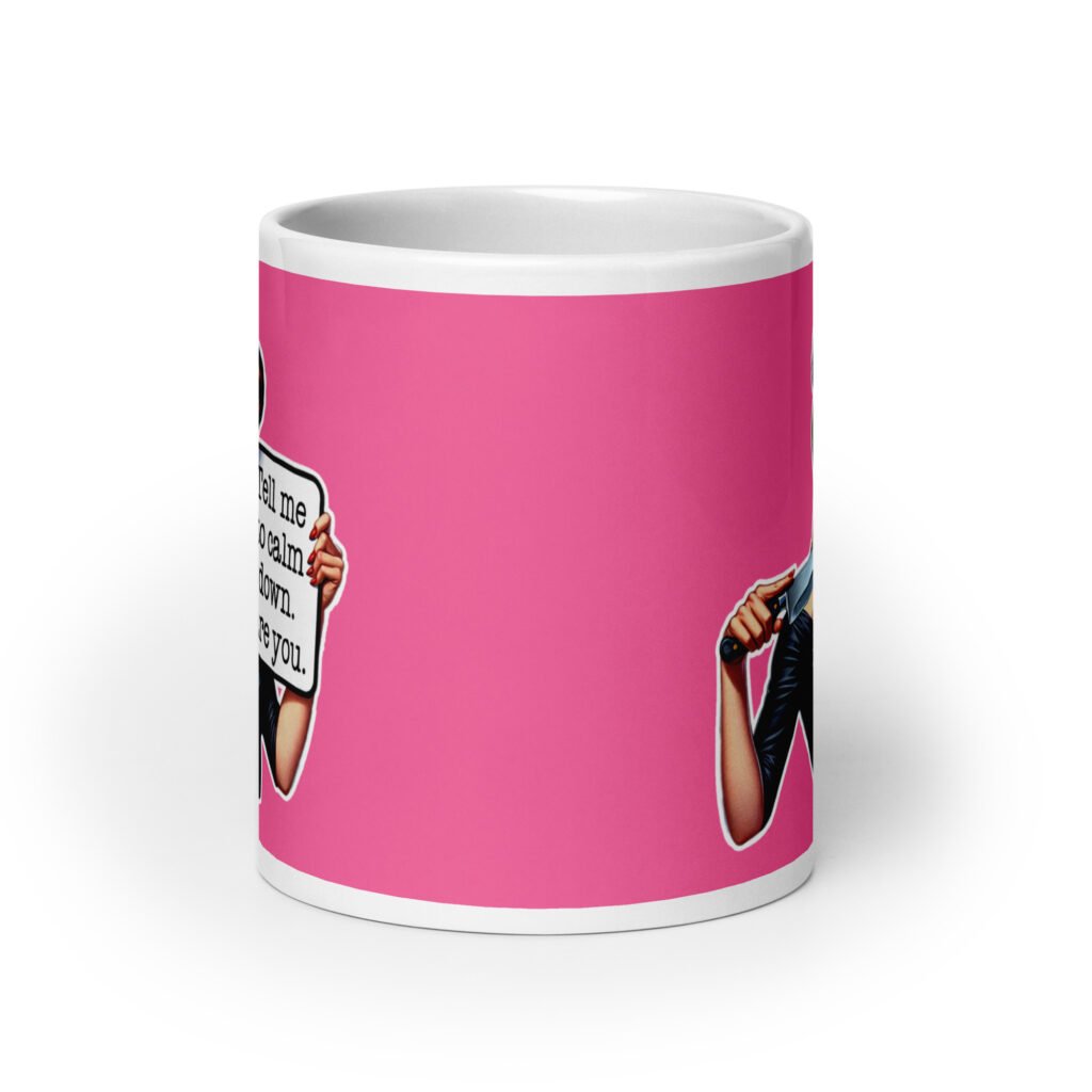 White ceramic coffee mug with pink color wrapped around. The mug has a graphic of an angry looking retro woman holding a knife and a sign. The sign says 'Tell me to calm down. I dare you.' The graphic is printed on both sides of the mug.