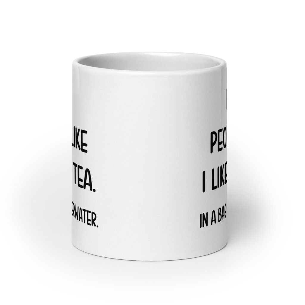 White ceramic coffee mug with the phrase 'I like people like I like my tea. In a bag & underwater' printed on both sides.