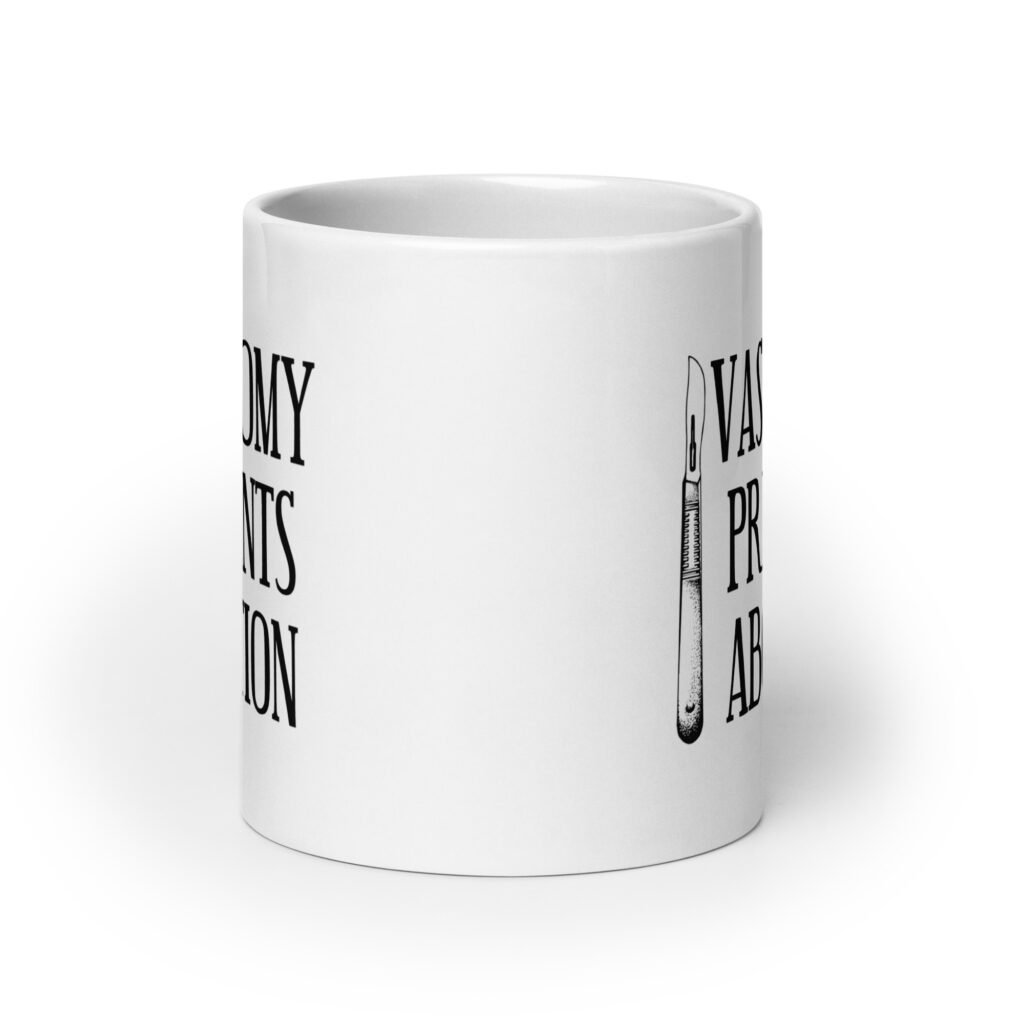 White ceramic coffee mug that has an image of a surgical scalpel and the phrase 'Vasectomy prevents abortion' printed on both sides.