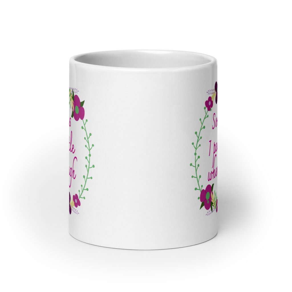 White ceramic coffee mug that has a colorful minimalistic style line drawing floral wreath with the text 'Sometimes I pee a little when I laugh' printed in the center of the wreath. The graphics are printed on both sides of the mug.
