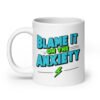 White ceramic mug with the phrase 'Blame is on the anxiety' printed on both sides of the mug. The graphics are bold and in aqua and lime green.