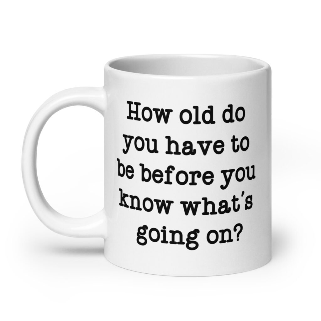 White ceramic mug with the text 'How old do you have to be before you know what's going on?' printed on both sides.