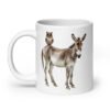 White ceramic coffee mug with an image of a donkey with wise owl sitting on it printed on both sides of the mug.