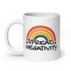 White ceramic coffee mug with a graphic of a rainbow and the words 'Spread negativity' printed on both sides.