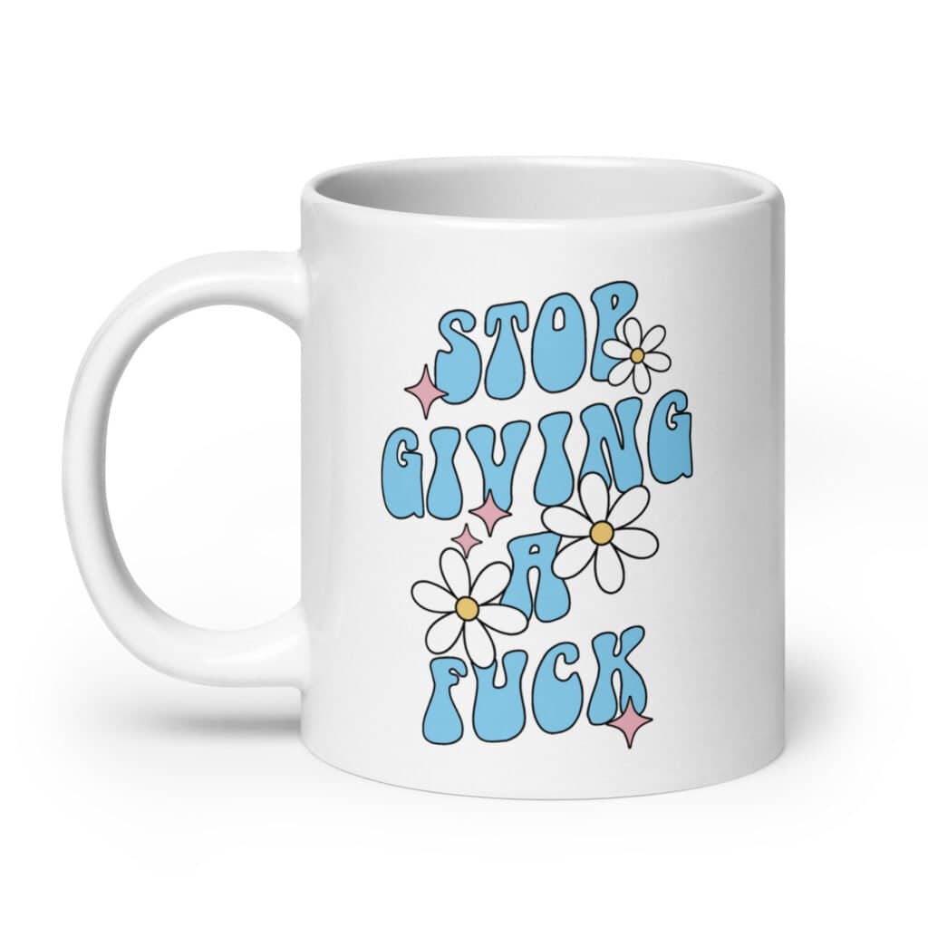 White ceramic coffee mug with a retro daisy and star design and the text 'Stop giving a fuck' printed on both sides.