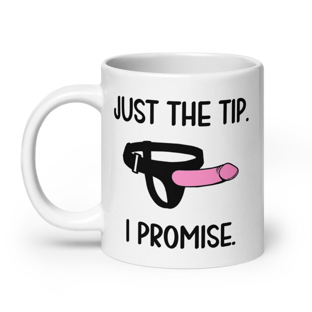 White ceramic coffee mug that has an image of a strap-on dildo and the words 'Just the tip. I promise.' printed on both sides.