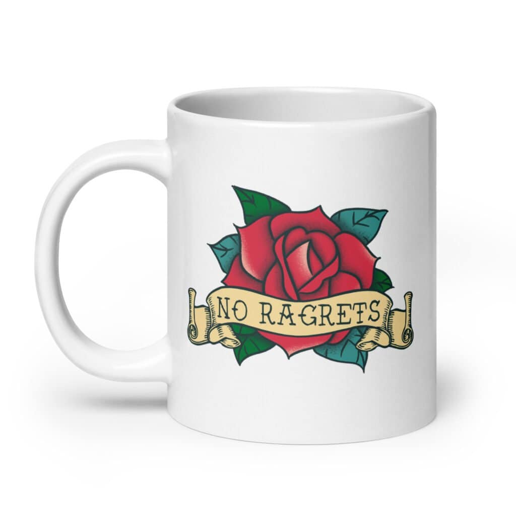 White ceramic coffee mug with funny image of an old school rose flash tattoo with the words 'No ragrets' intentionally misspelled. The graphics are printed on both sides of the mug.