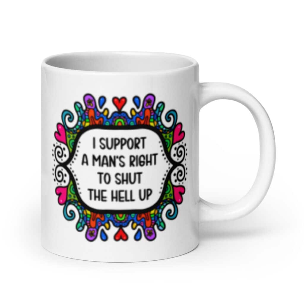 White ceramic mug with a colorful doodle graphic and the words 'I support a man's right to shut the hell up.' The design is printed on both sides of the mug.