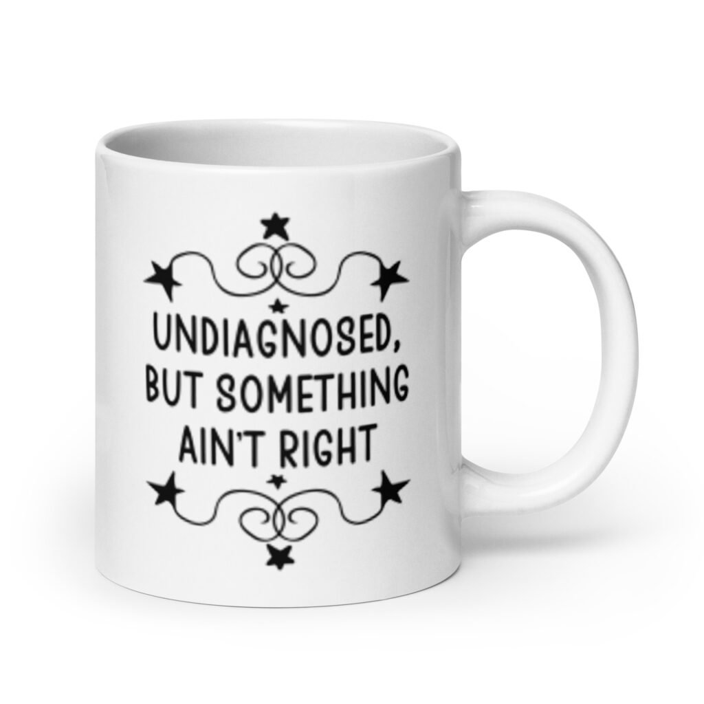 White ceramic mug with the text 'Undiagnosed, but something ain't right' printed on both sides.