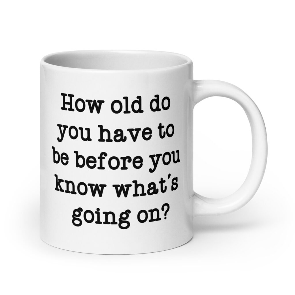 White ceramic mug with the text 'How old do you have to be before you know what's going on?' printed on both sides.