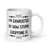 White ceramic coffee mug with the text 'I'm exhausted by how stupid everyone is' printed on both sides of the mug.