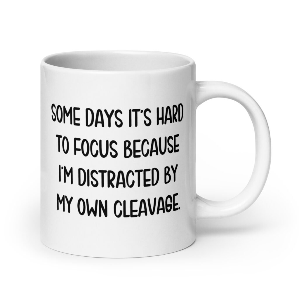 White ceramic mug with the phrase 'Some days it's hard to focus because I'm distracted by my own cleavage' printed on both sides.