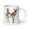 White ceramic coffee mug with an image of a donkey with wise owl sitting on it printed on both sides of the mug.