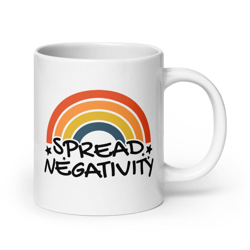 White ceramic coffee mug with a graphic of a rainbow and the words 'Spread negativity' printed on both sides.