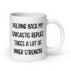White ceramic mug with the phrase 'Holding back my sarcastic replies takes a lot of inner strength' printed on both sides of the mug.
