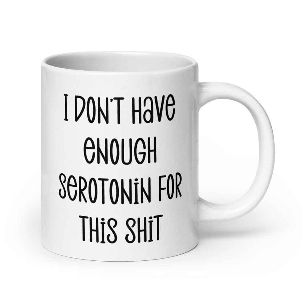 White ceramic coffee mug with the text 'I don't have enough serotonin for this shit' printed on both sides.