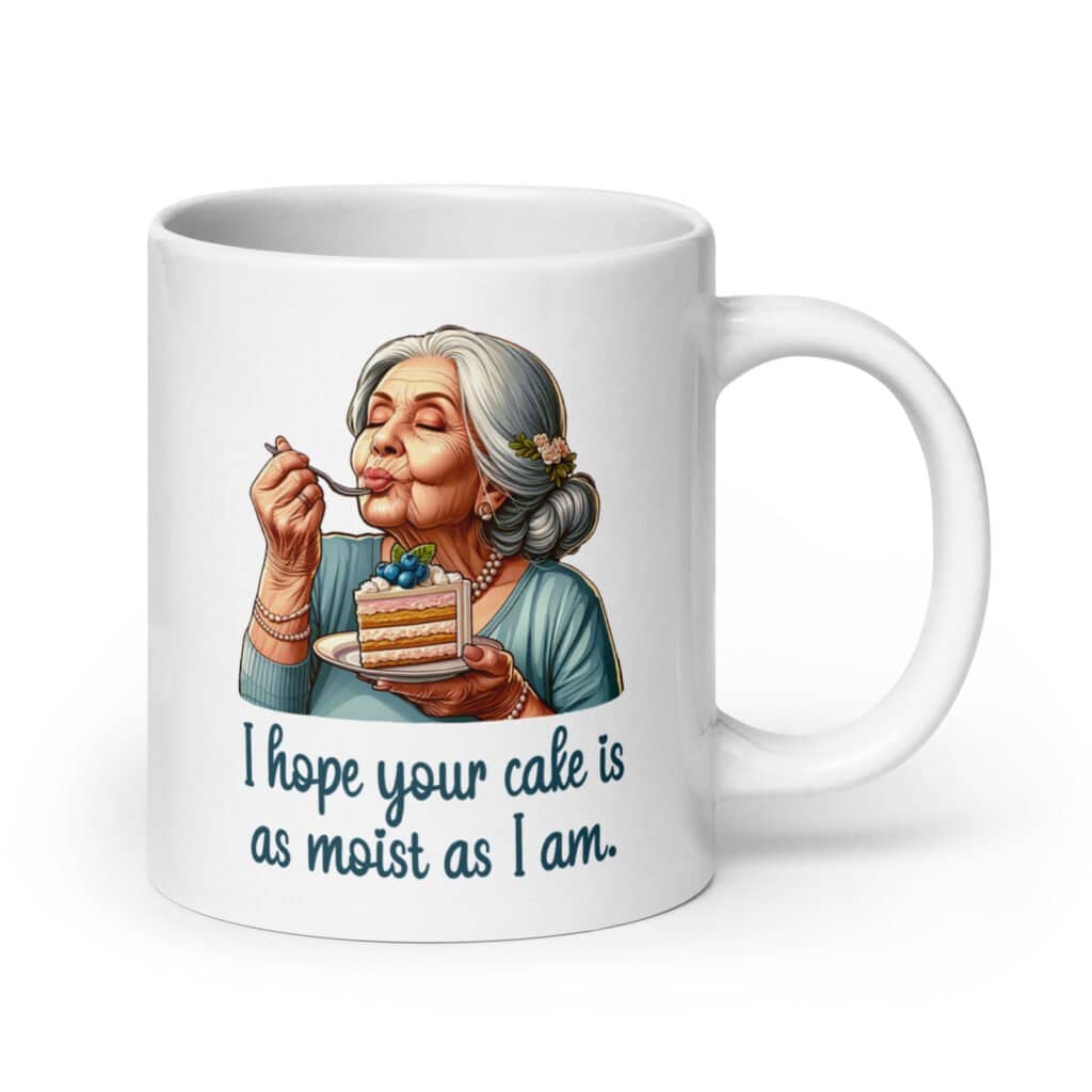 White ceramic coffee mug with an image of grey haired older woman enjoying a bite of a piece of cake with the words 'I hope your cake is as moist as I am' printed on both sides.