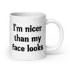 White ceramic coffee mug with the text 'I'm nicer than my face looks' printed on both sides.