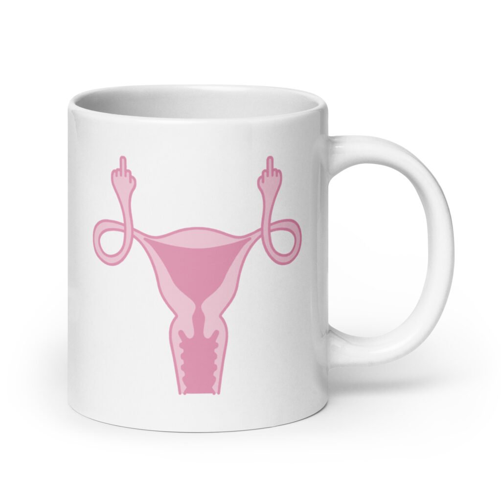 White ceramic coffee mug with with image of a pink uterus flipping middle finger graphic printed on both sides.