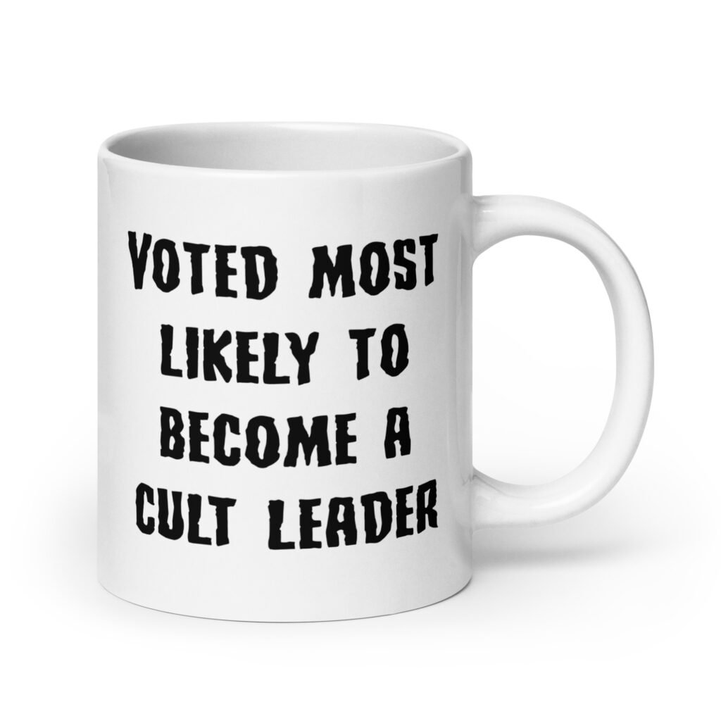 White ceramic coffee mug with the text 'Voted most likely to become a cult leader' printed on both sides.