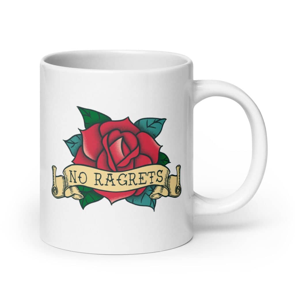 White ceramic coffee mug with funny image of an old school rose flash tattoo with the words 'No ragrets' intentionally misspelled. The graphics are printed on both sides of the mug.