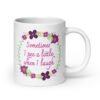 White ceramic coffee mug that has a colorful minimalistic style line drawing floral wreath with the text 'Sometimes I pee a little when I laugh' printed in the center of the wreath. The graphics are printed on both sides of the mug.