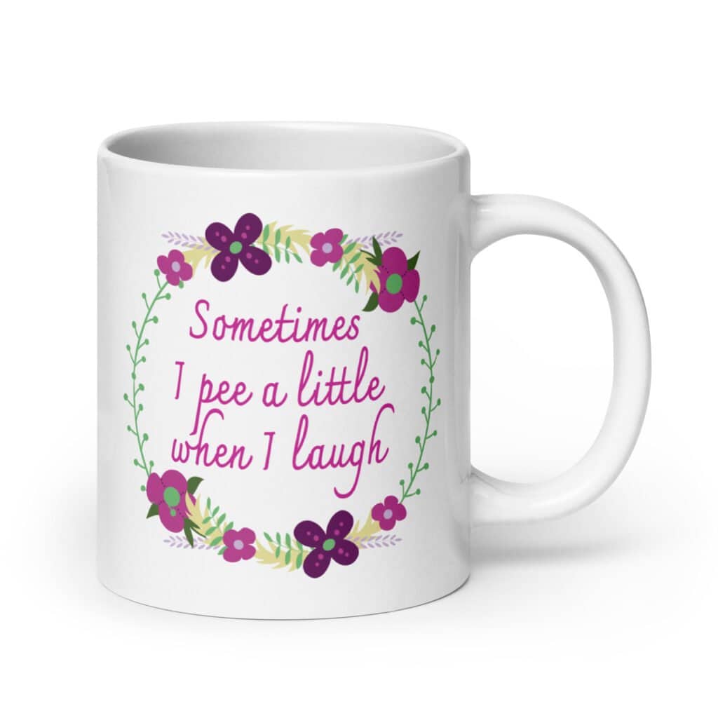 White ceramic coffee mug that has a colorful minimalistic style line drawing floral wreath with the text 'Sometimes I pee a little when I laugh' printed in the center of the wreath. The graphics are printed on both sides of the mug.