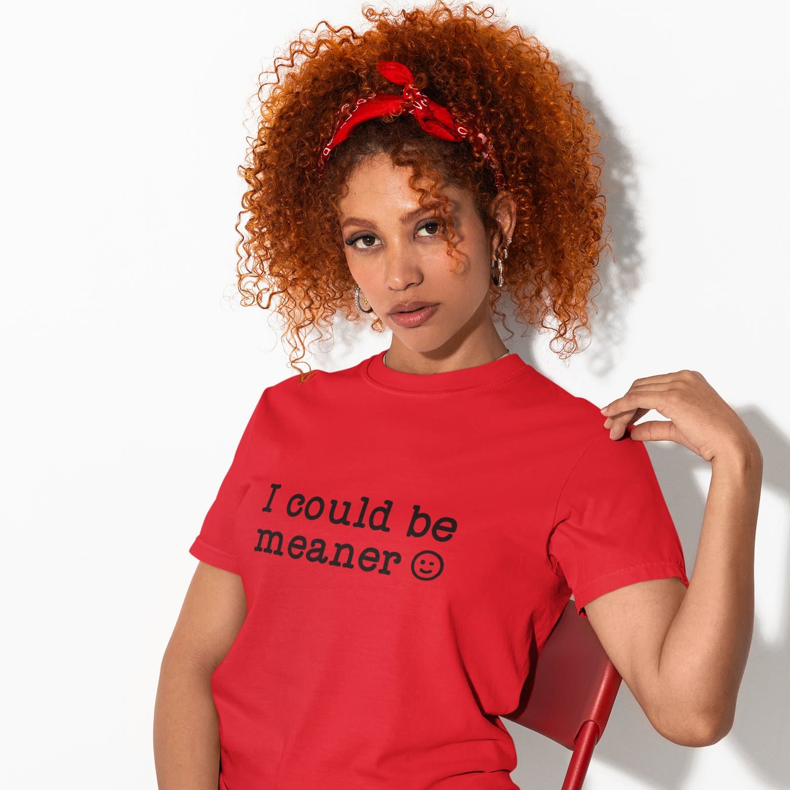 Woman wearing a red t-shirt with the text 'I could be meaner' printed on the front.