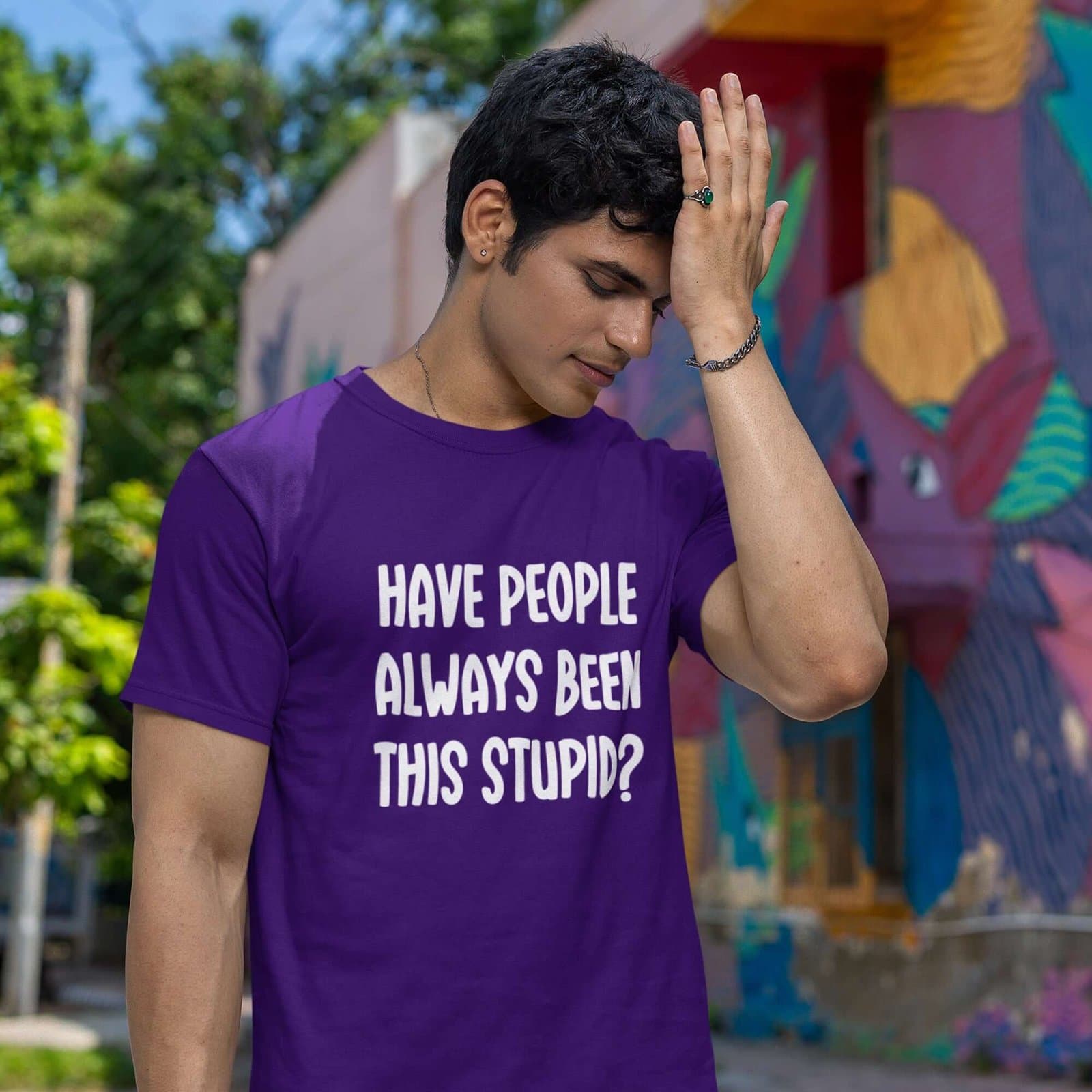 Man wearing a purple t-shirt with the question 'Have people always been this stupid?' printed on the front.