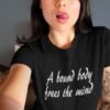 Woman wearing a black t-shirt with the text 'A bound body frees the mind' printed on the front.