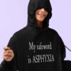 Woman wearing a black hoodie sweatshirt with the drawstrings pulled around her face. The text 'My safeword is asphyxia' is printed on the front of the hoodie.