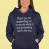 Woman wearing a navy blue hoodie sweatshirt with the text 'Thank you for pretending not to see me while I was pretending not to see you.' printed on the front.