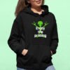 Woman wearing a black hoodie sweatshirt with an image of a green alien and the text 'Enjoy the probing' printed on the front.