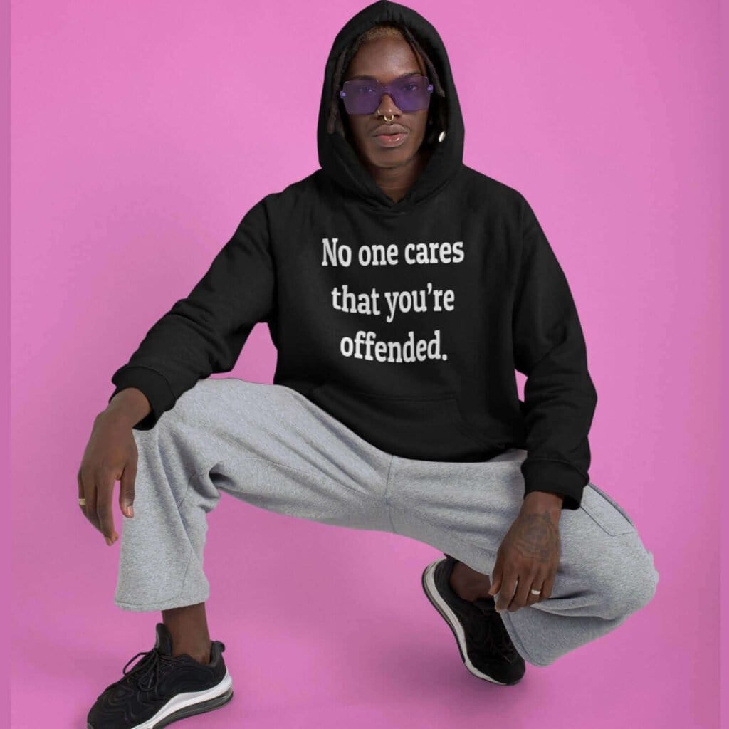 Man wearing a black hoodie sweatshirt with the text 'No one cares that you're offended.' printed on the front.
