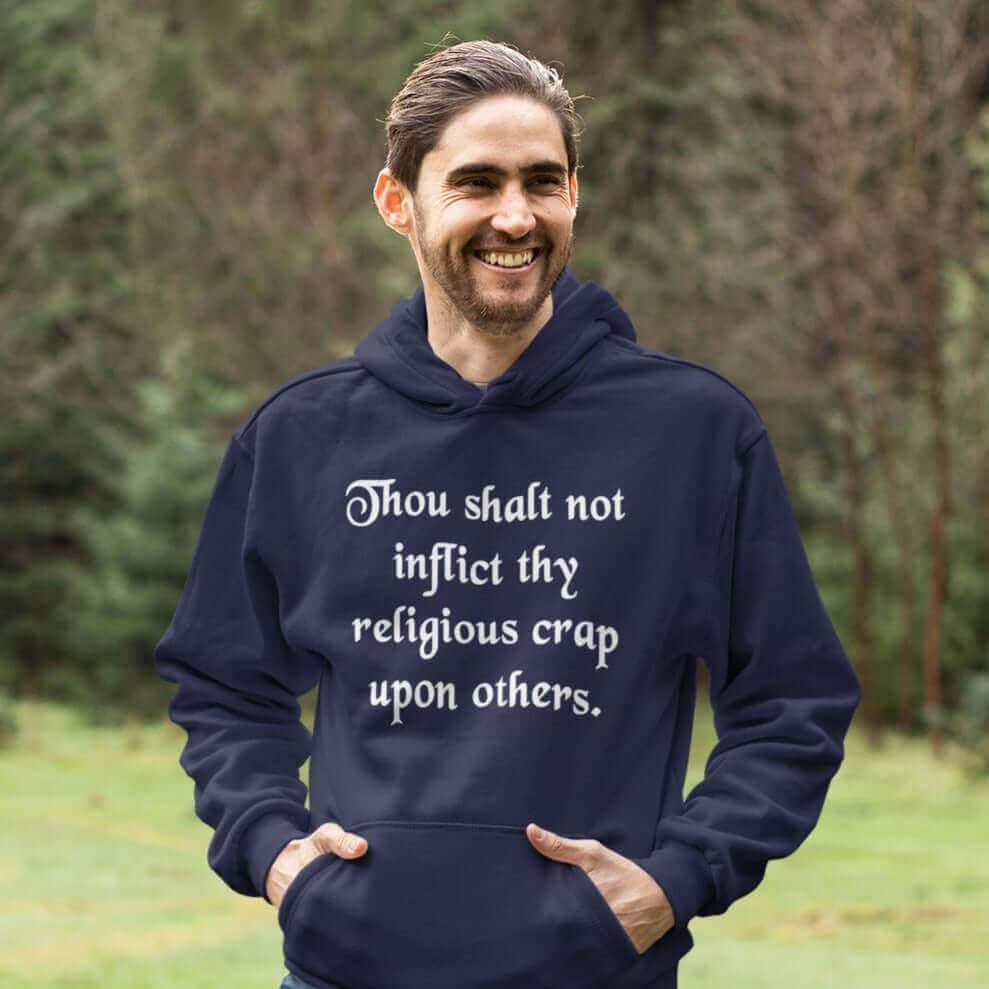 Smiling man wearing a navy blue biblical satire hoodie sweatshirt with the text 'Thou shalt not inflict thy religious crap upon others.' printed on the front.