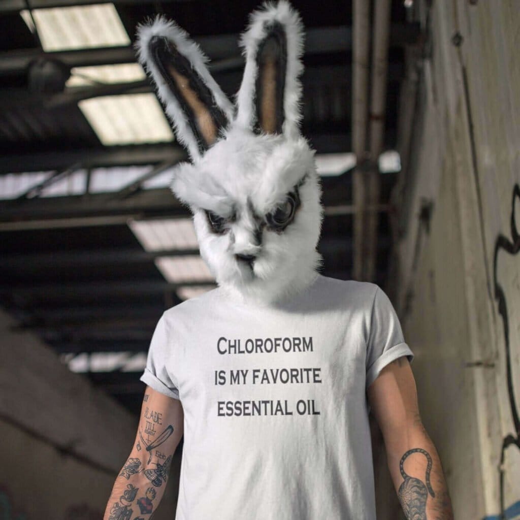 Man wearing a creepy bunny mask and a white t-shirt with the text 'Chloroform is my favorite essential oil' printed on the front.
