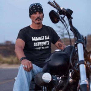 Man sitting on motorcycle wearing a black t-shirt with the text 'Against all authority except my mom' printed on the front.
