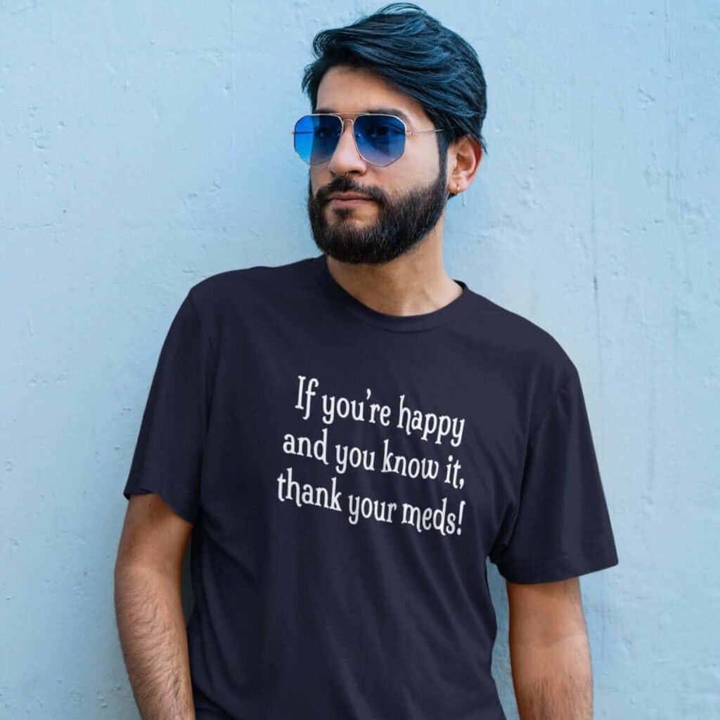 Man wearing a navy blue t-shirt with the text 'If you're happy and you know it, thank your meds!' printed on the front.
