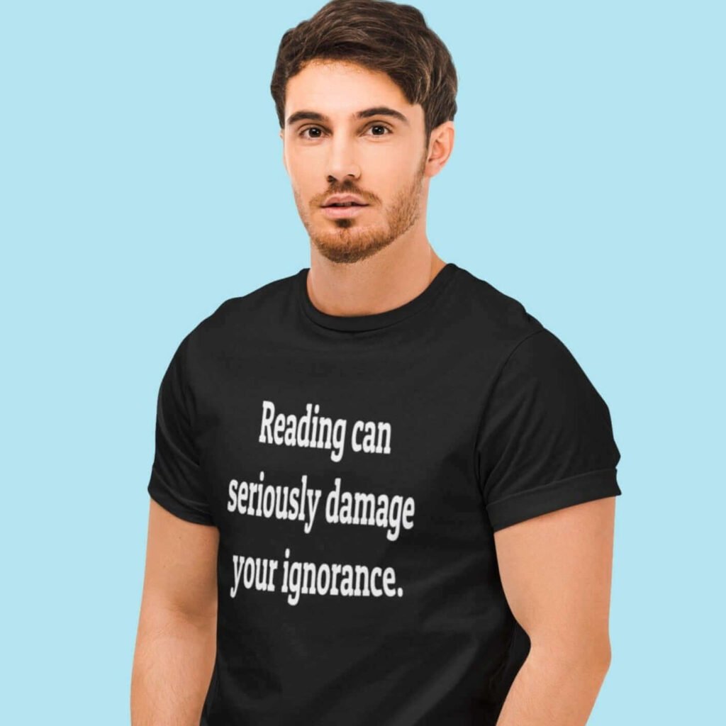 Man wearing a black t-shirt with the text 'Reading can seriously damage your ignorance.' printed on the front.