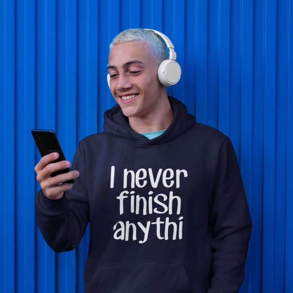 Man wearing a navy blue hoodie sweatshirt with the text 'I never finish anyth' printed on the front.