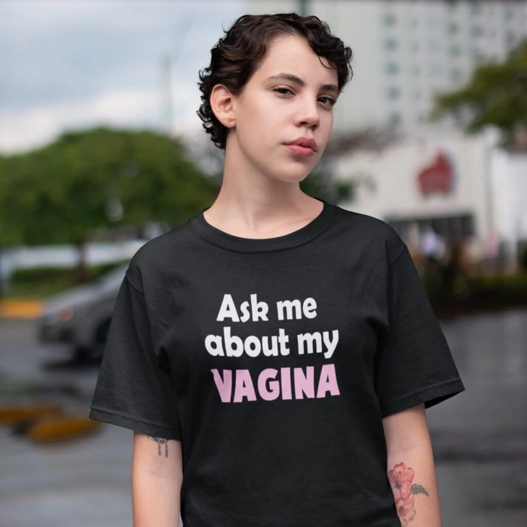 Woman wearing a black t-shirt with the text 'Ask me about my VAGINA' printed on the front.
