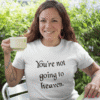 Woman drinking a cup of coffee wearing a white t-shirt with the text 'You're not going to heaven.' printed on the front.