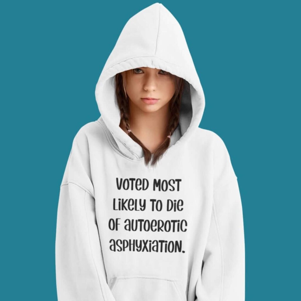 Woman wearing white hoodie sweatshirt with the hood up covering some of her face. The hoodie has the text 'Voted most likely to die of autoerotic asphyxiation.' printed on the front.