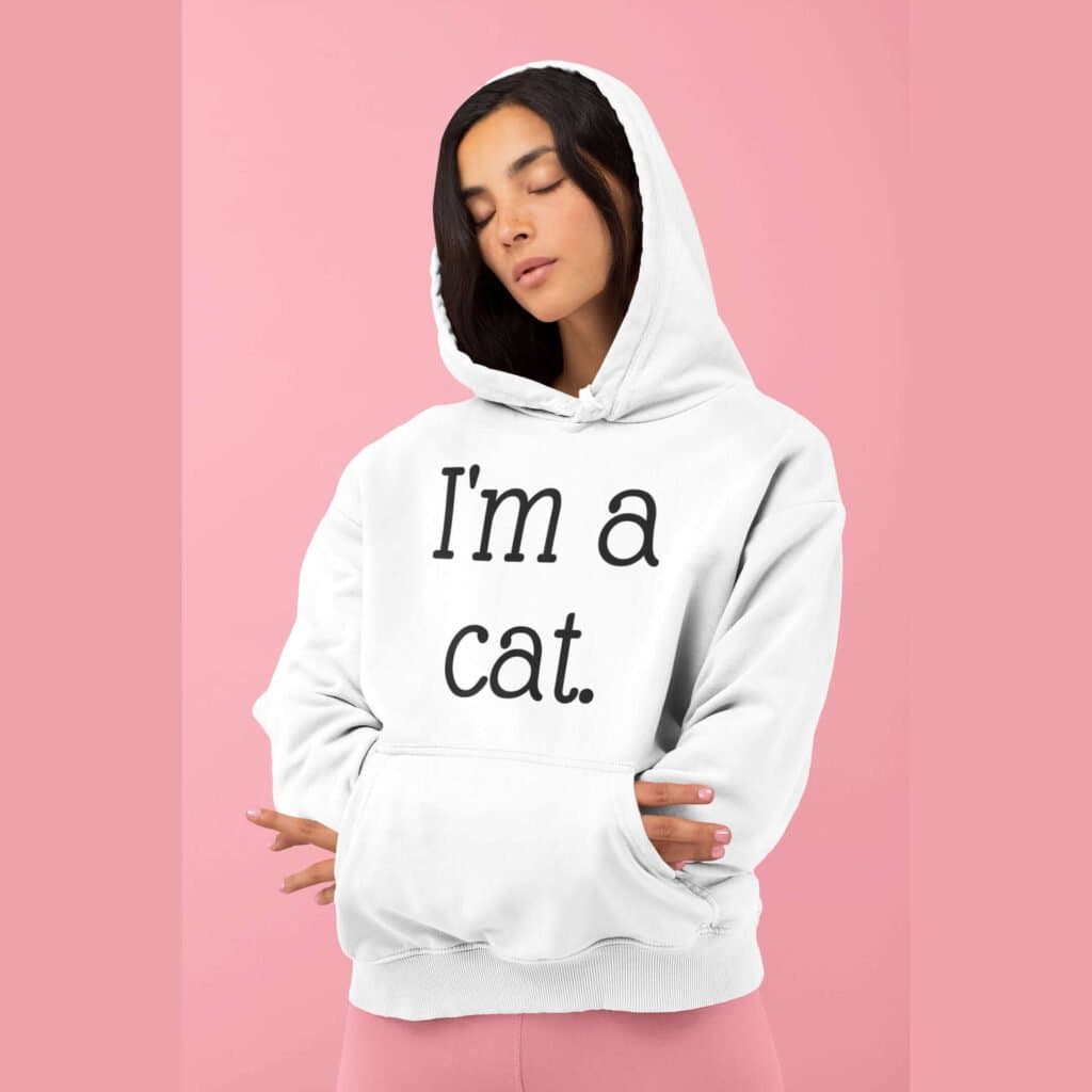 Woman wearing white hoodie sweatshirt with the text 'I'm a cat' printed on the front.