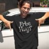 Woman wearing a black t-shirt with the text 'Free Hugs' printed on the front.