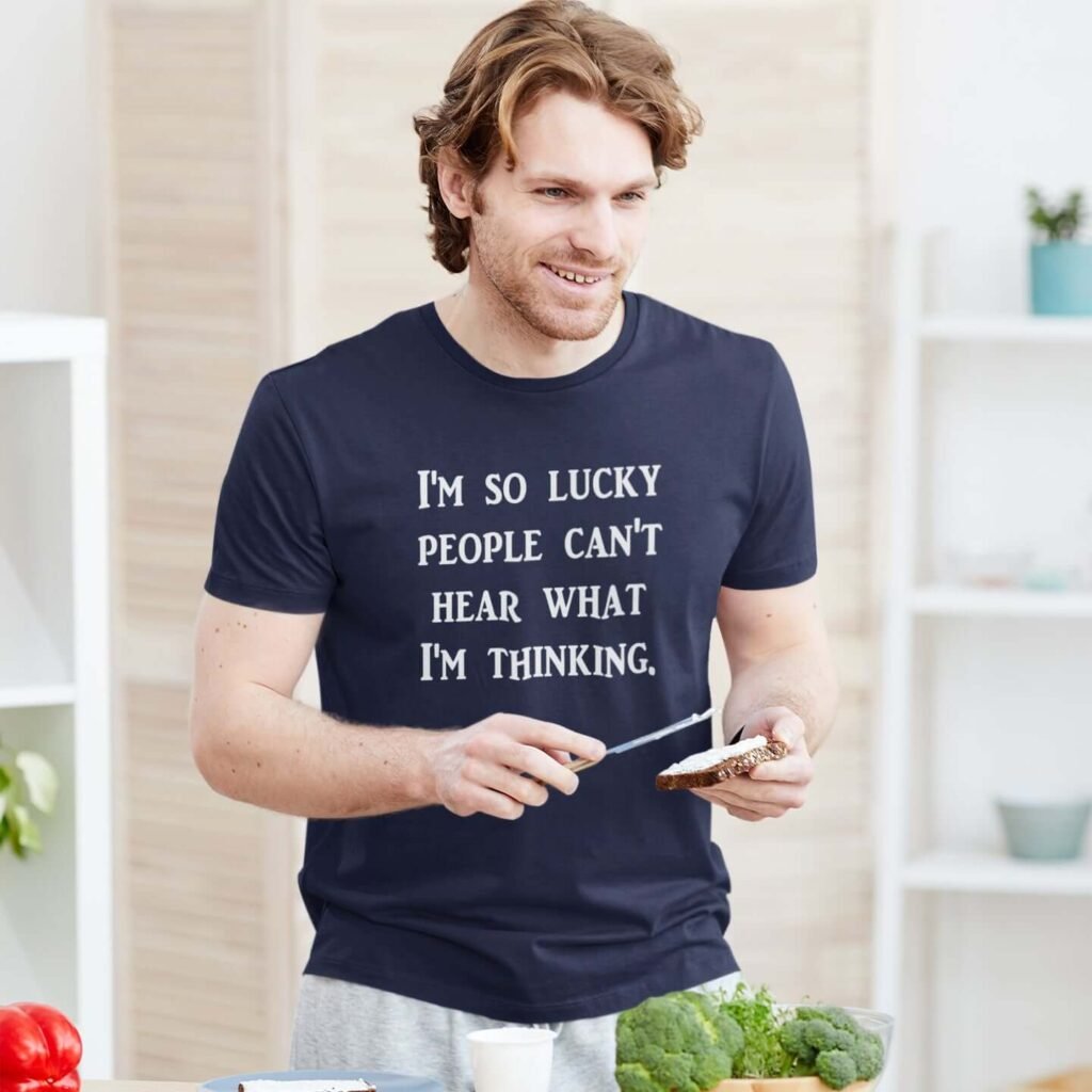 Man wearing a navy blue t-shirt with the text 'I'm so lucky people can't hear what I'm thinking.' printed on the front.