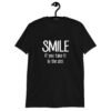 Black t-shirt with the text 'Smile if you take it in the ass' printed on the front. The word 'smile' is large and the words 'take it in the ass' are much smaller.