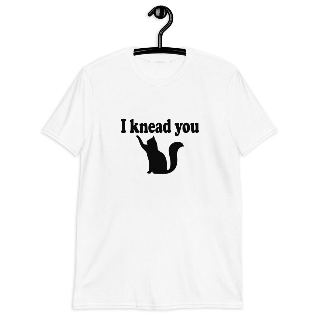 White t-shirt that has an image of a silhouette of a cat and the text 'I knead you' printed on the front.