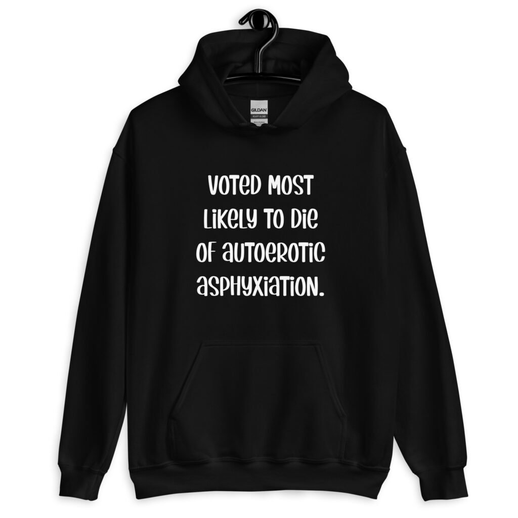 Black hoodie sweatshirt with the hood up covering some of her face. The hoodie has the text 'Voted most likely to die of autoerotic asphyxiation.' printed on the front.